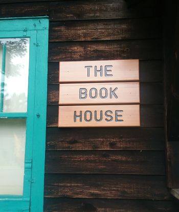 "The Book House" wall sign on a wood siding. 